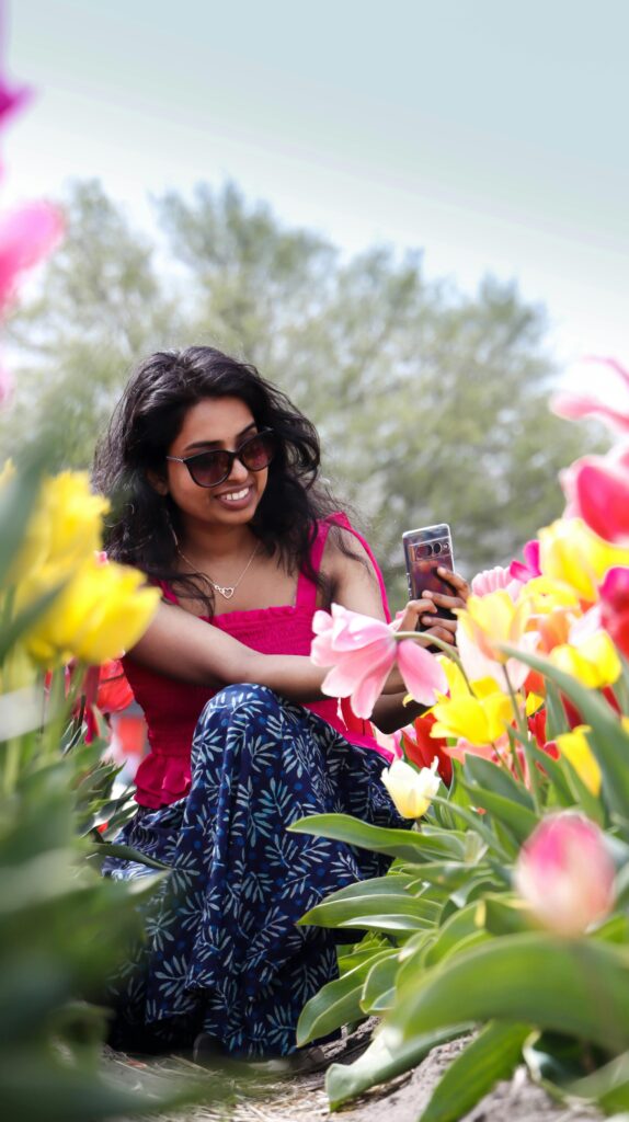A woman enjoying colorful tulips in an Amsterdam garden, capturing the essence of spring.